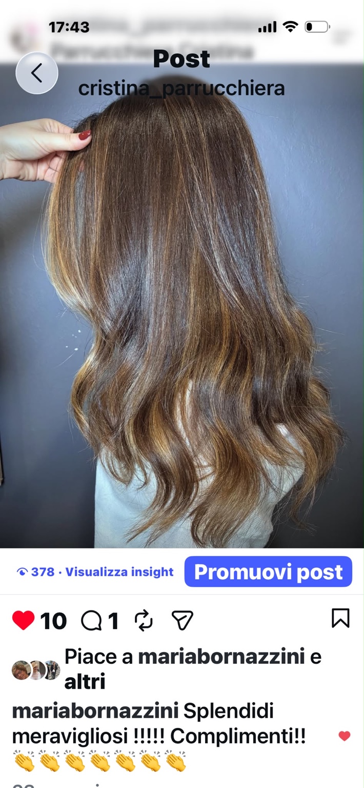 Capelli castani con riflessi dorati sulle lunghezze e onde morbide, visti da dietro